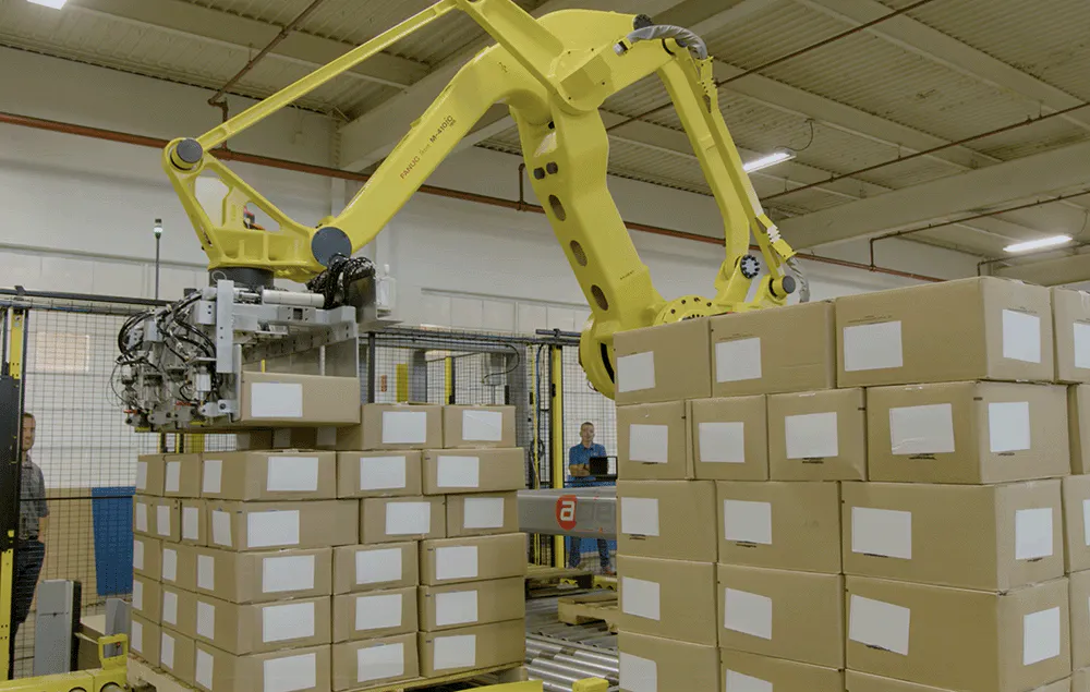 A yellow robot stacking boxes