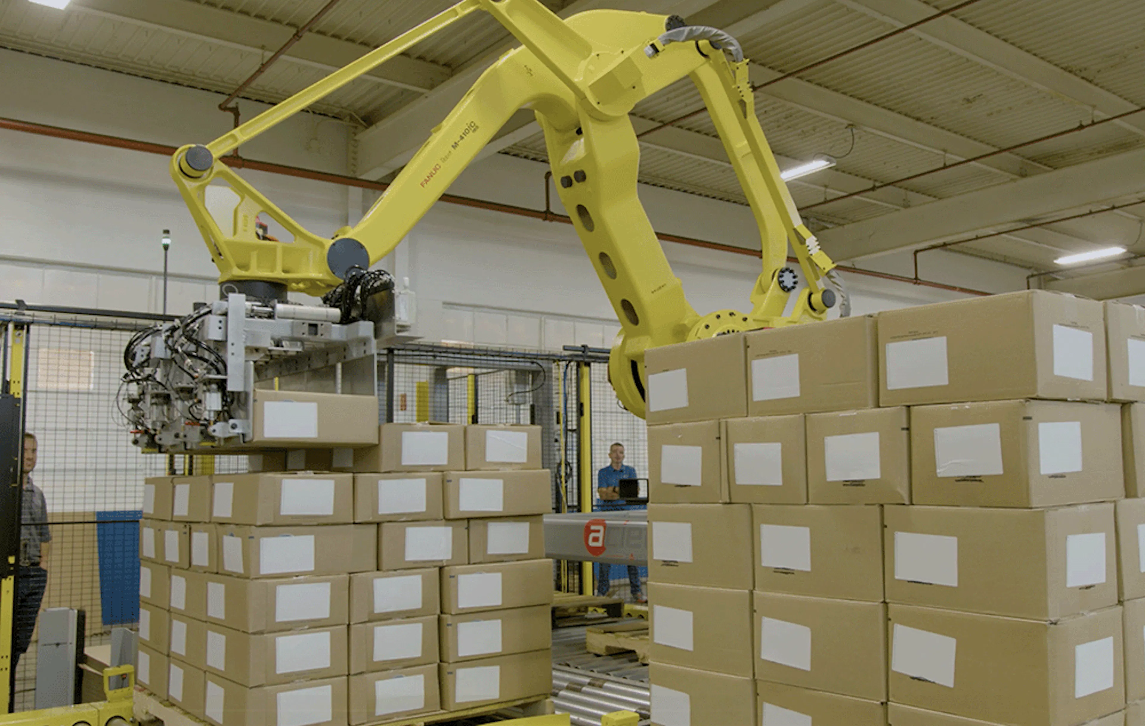 A yellow robot stacking boxes