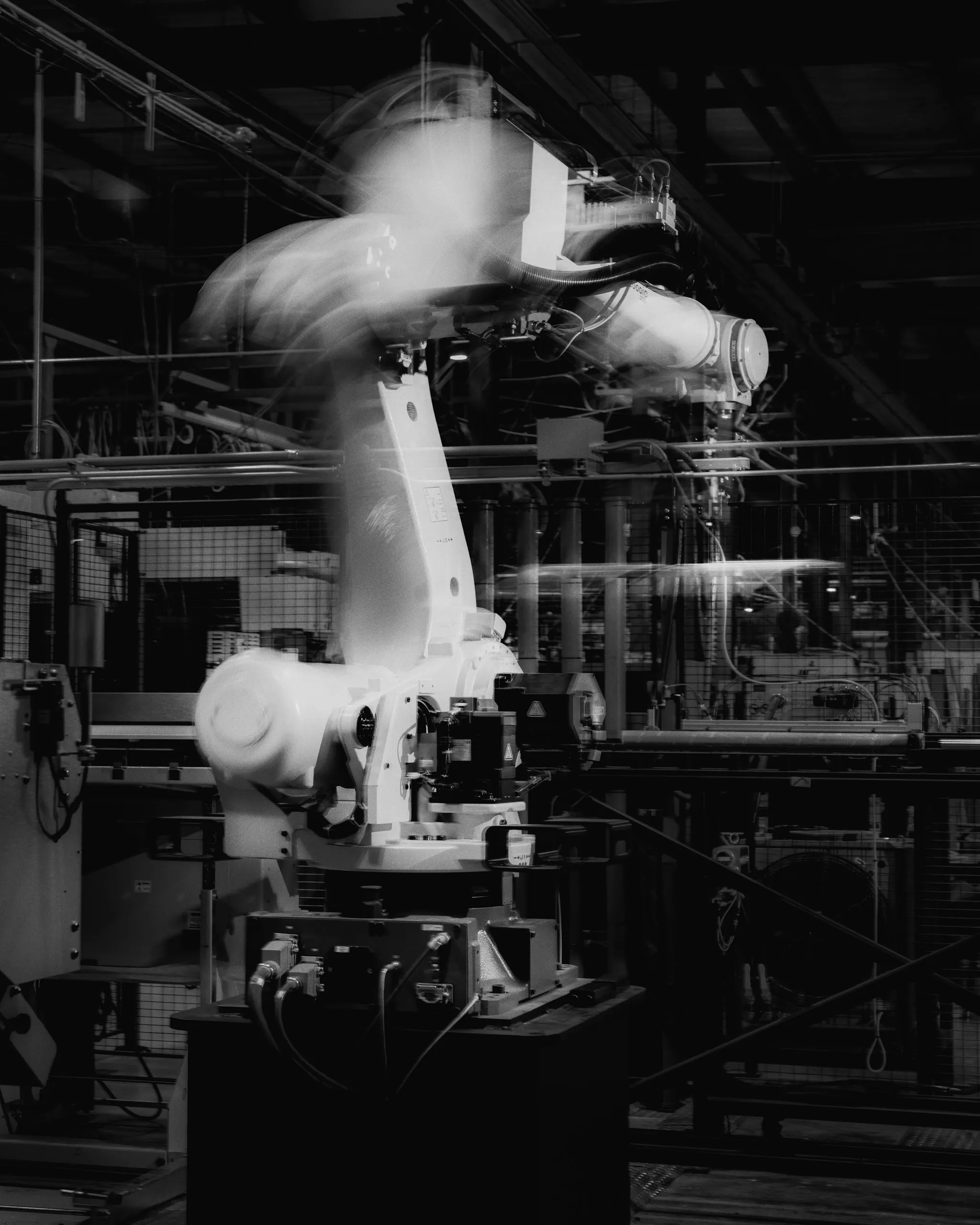 a black and white motion blur image of a FANUC robot used for robotic press brake