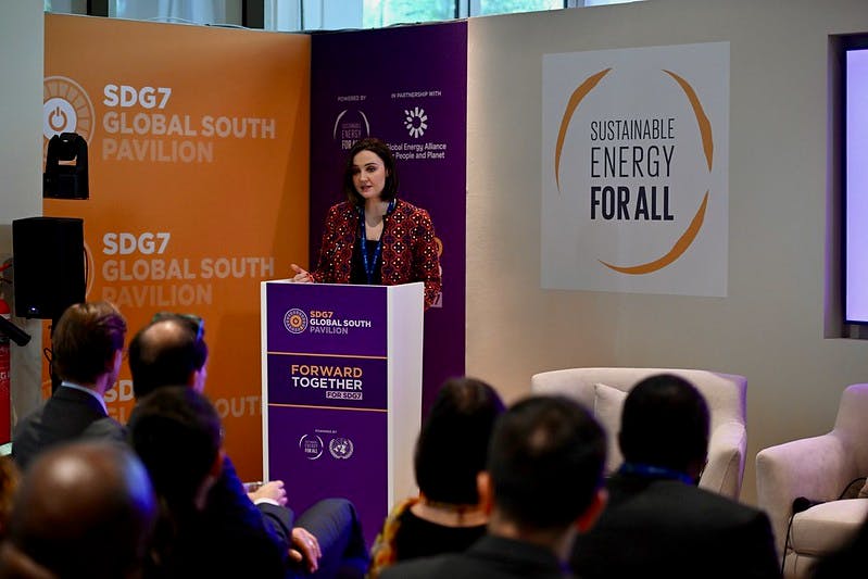 A woman speaking at a podium at a COP28 event