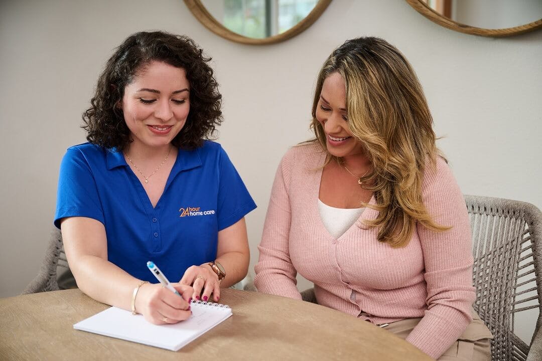 A caregiver and her client's mother go over the schedule for the week.