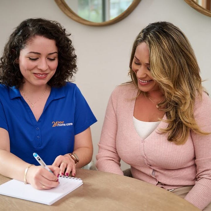 A caregiver and her client's mother go over the schedule for the week.