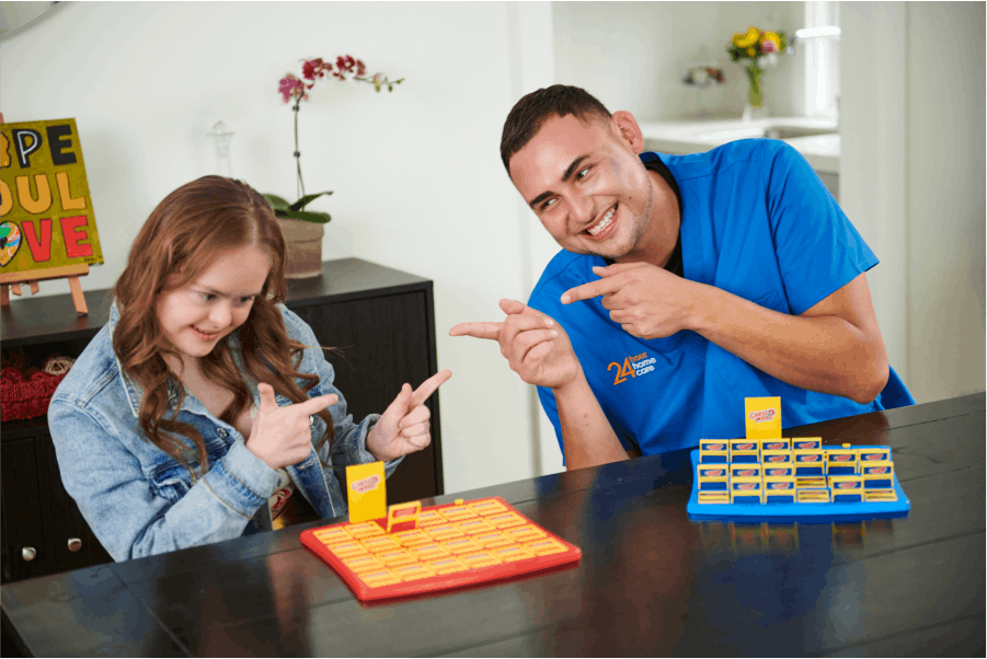 A caretaker and child playing "Guess Who" with each other