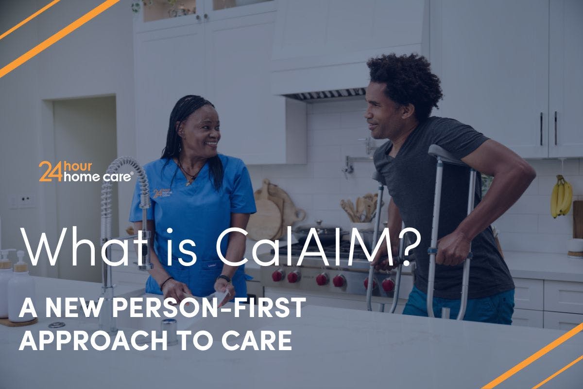 A man in crutches and his caregiver talk in the kitchen.
