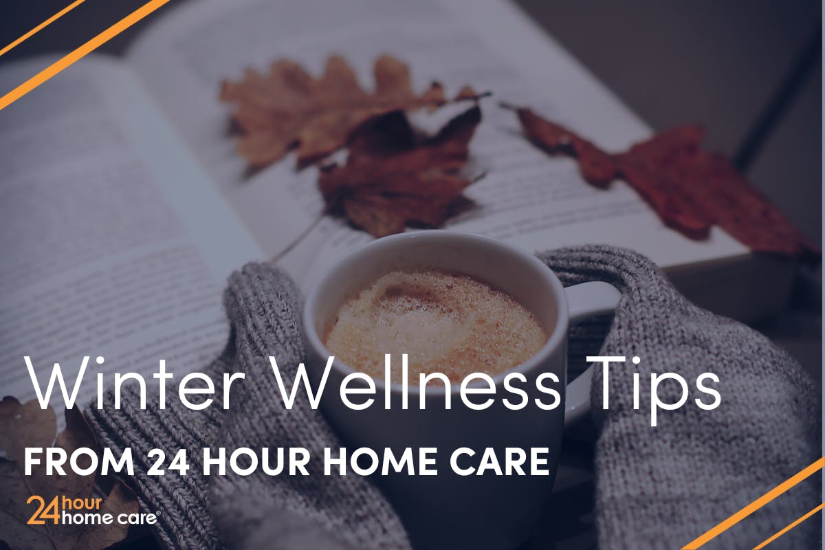 Cold hands hold a warm cup of coffee while a book is open in the background of the image.