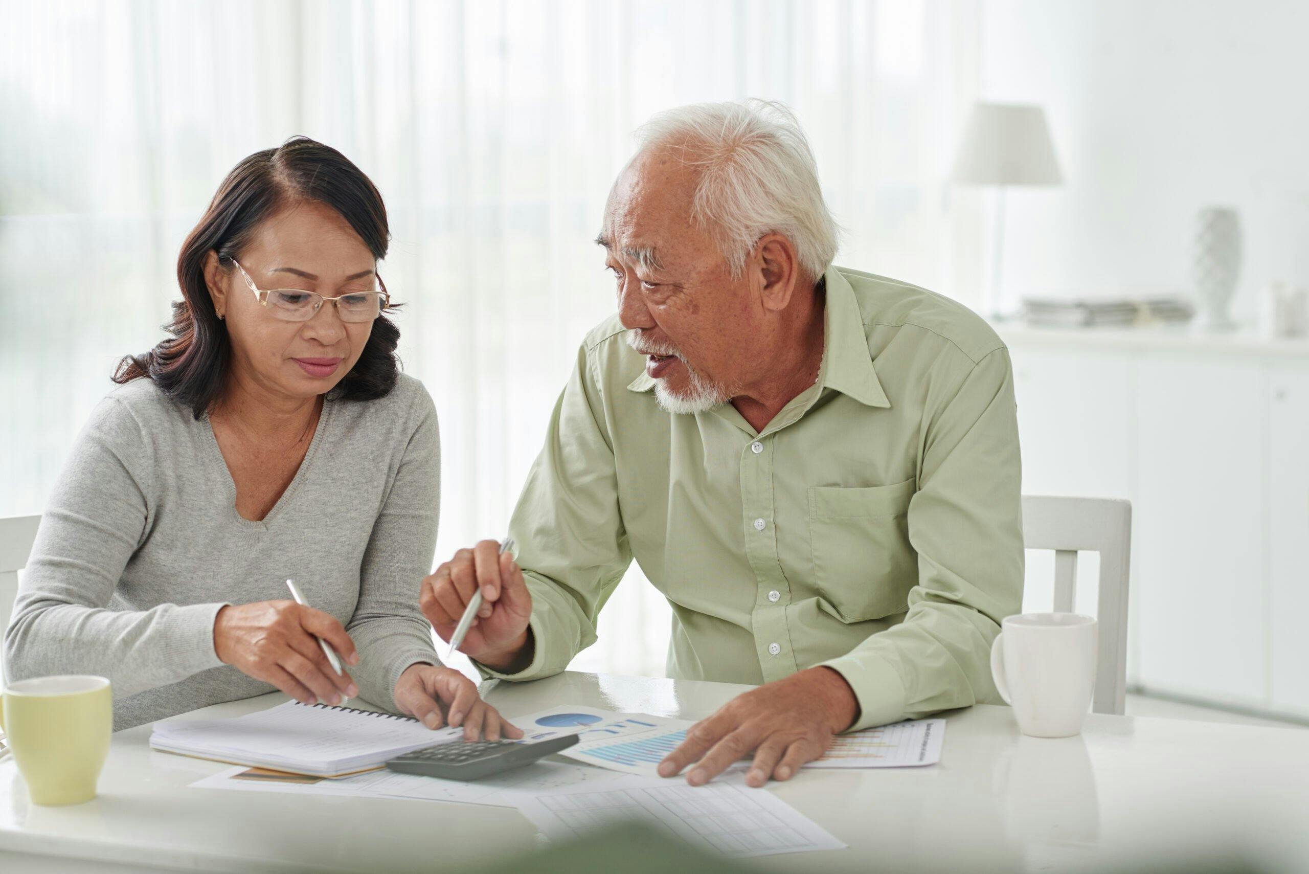 Senior,Business,Couple,Discussing,Financial,Documents