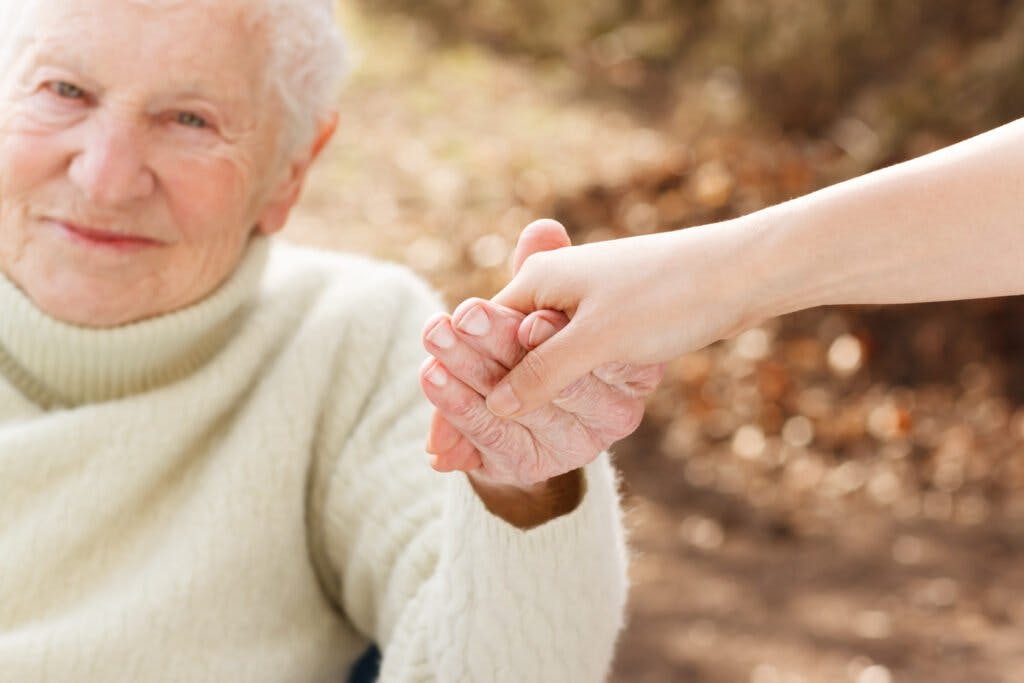 Senior woman holding hands with young lady