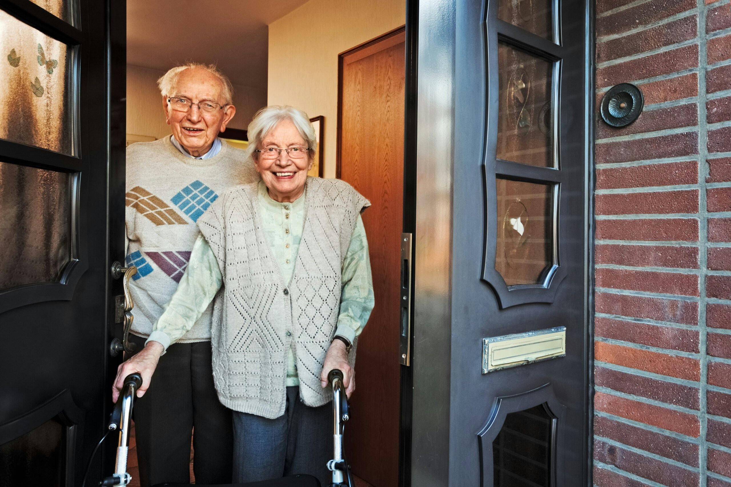 Happy,Elderly,Couple,Opening,The,Front,Door