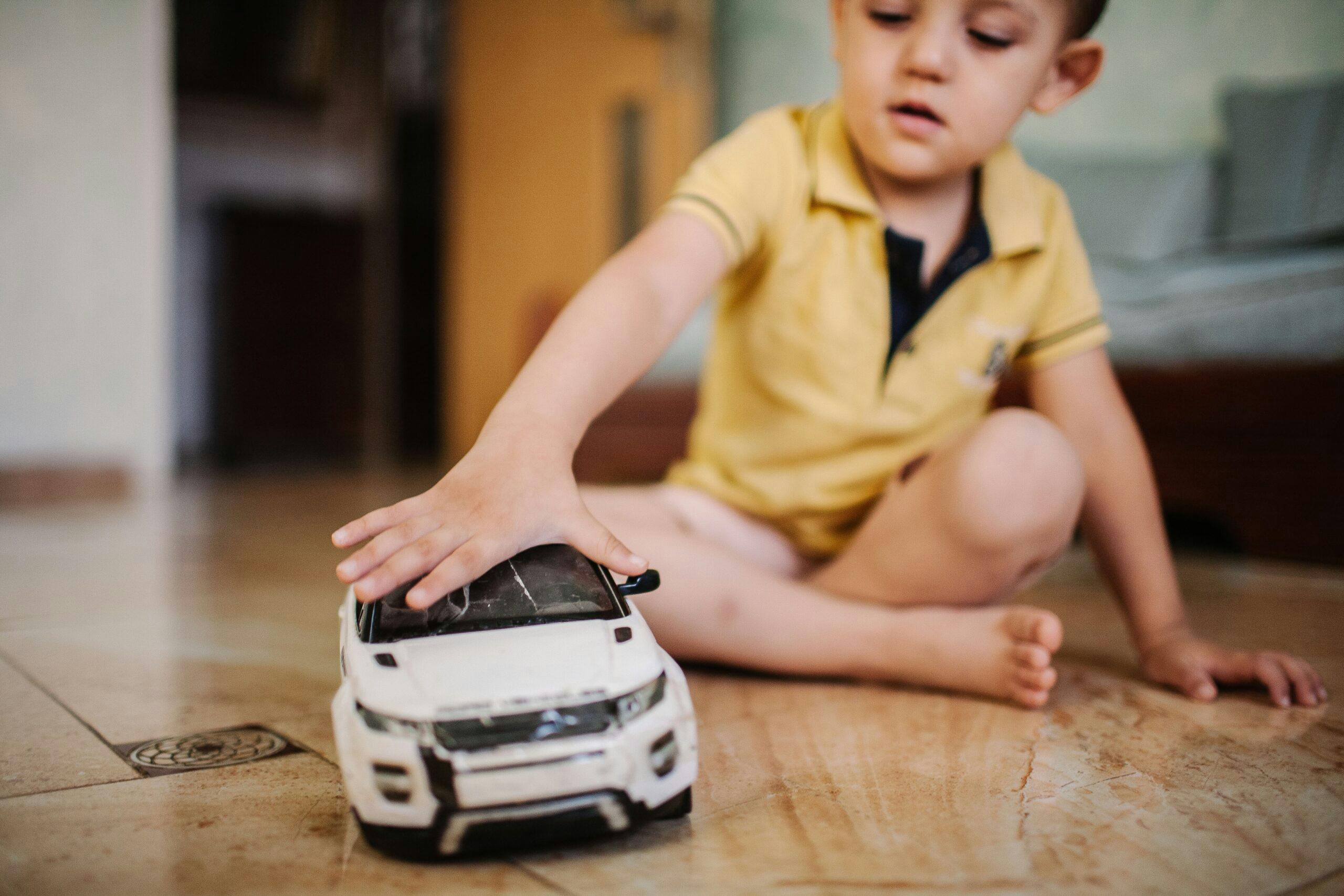 being-a-kid-on-the-ground-playing-car-toy-happy_t20_Blzr29