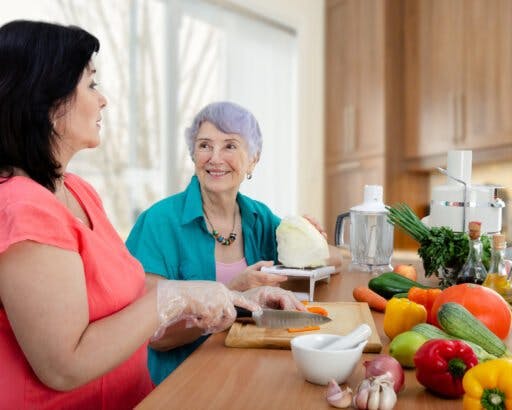 Caregiver preparing food for senior