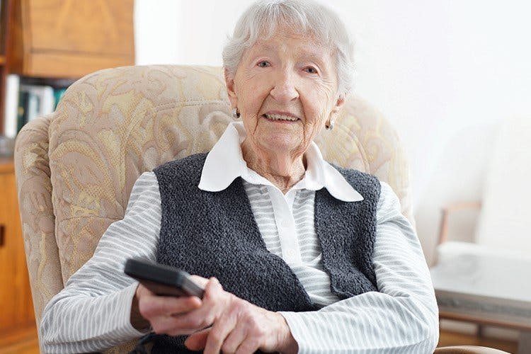 elderly-woman-operating-remote-control-in-rocking-chair