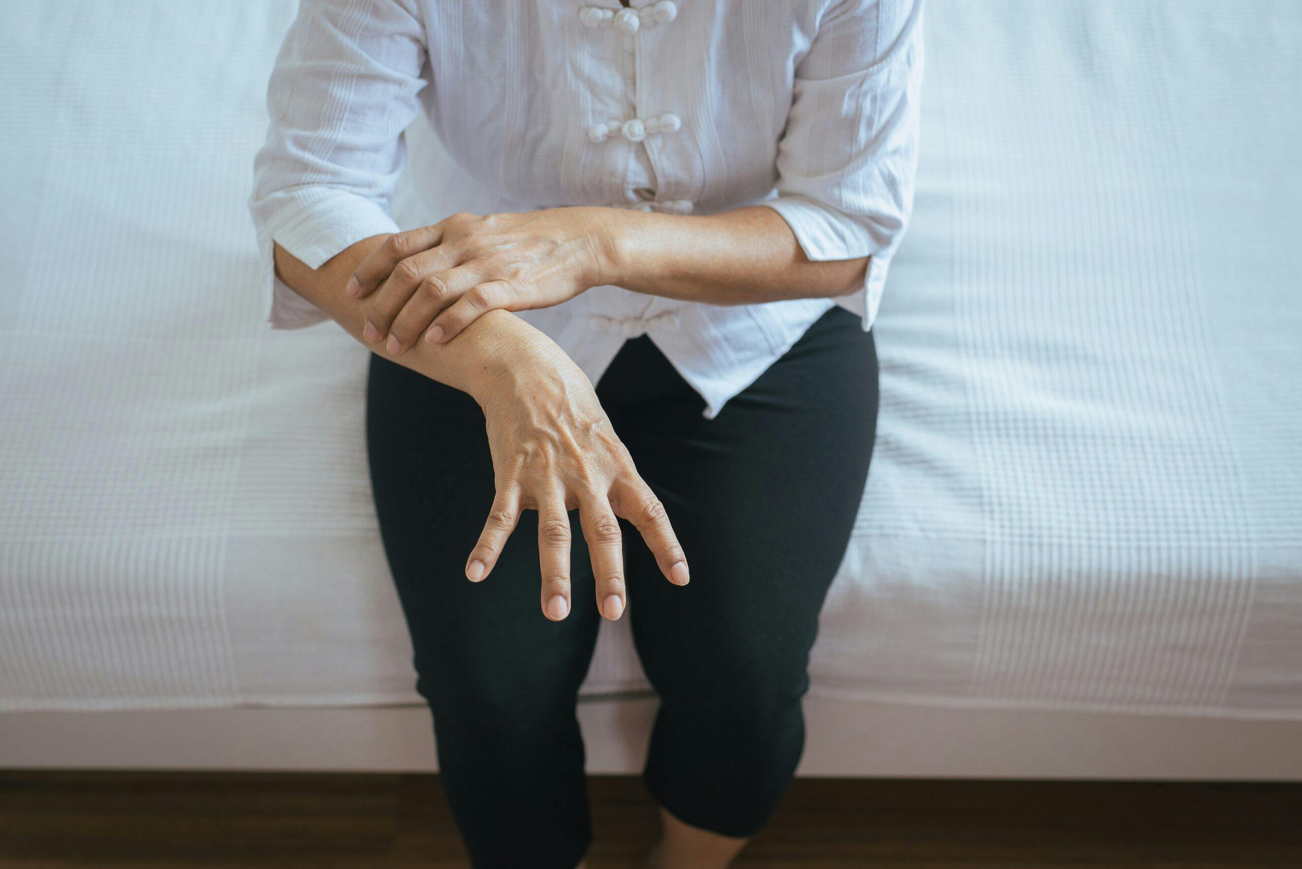 Elderly woman suffering with parkinson’s disease symptoms