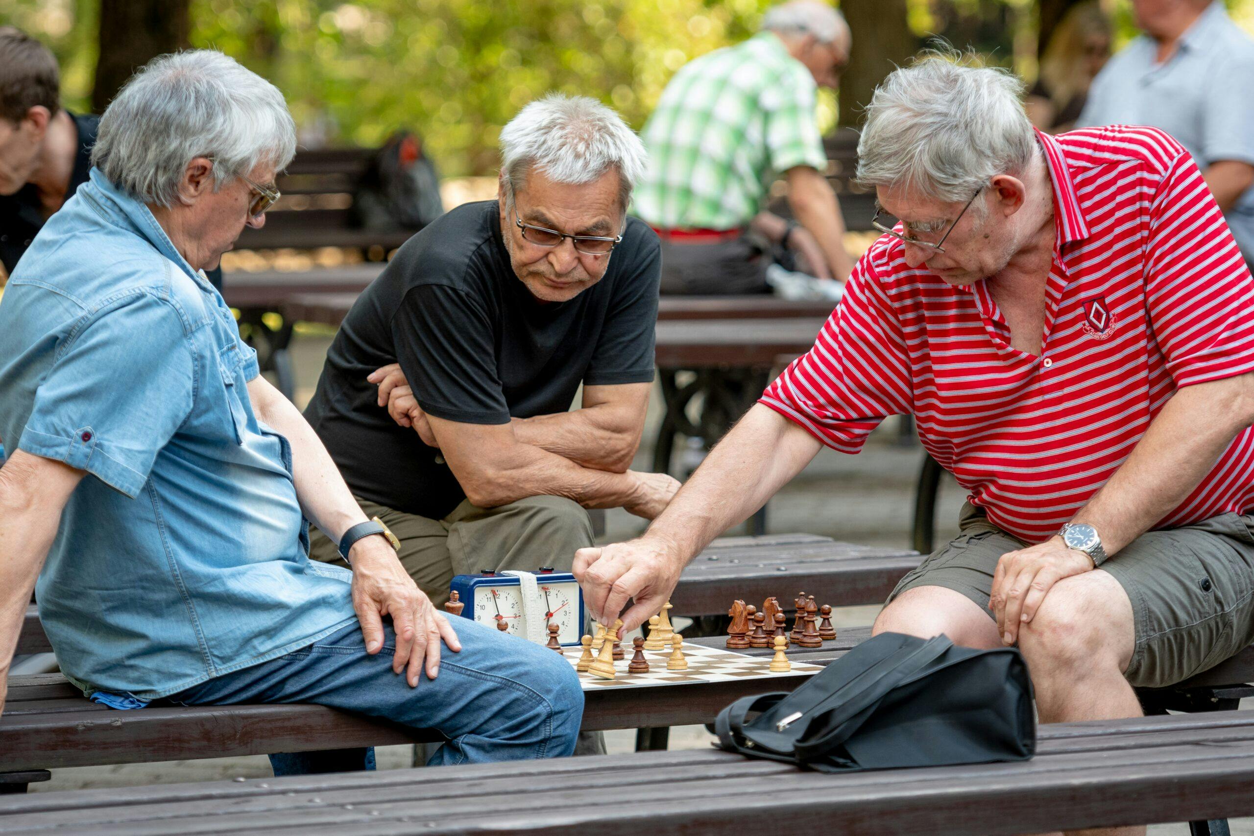 RIGA, LATVIA – JULY 18, 2018: Men seated on park benches and pla