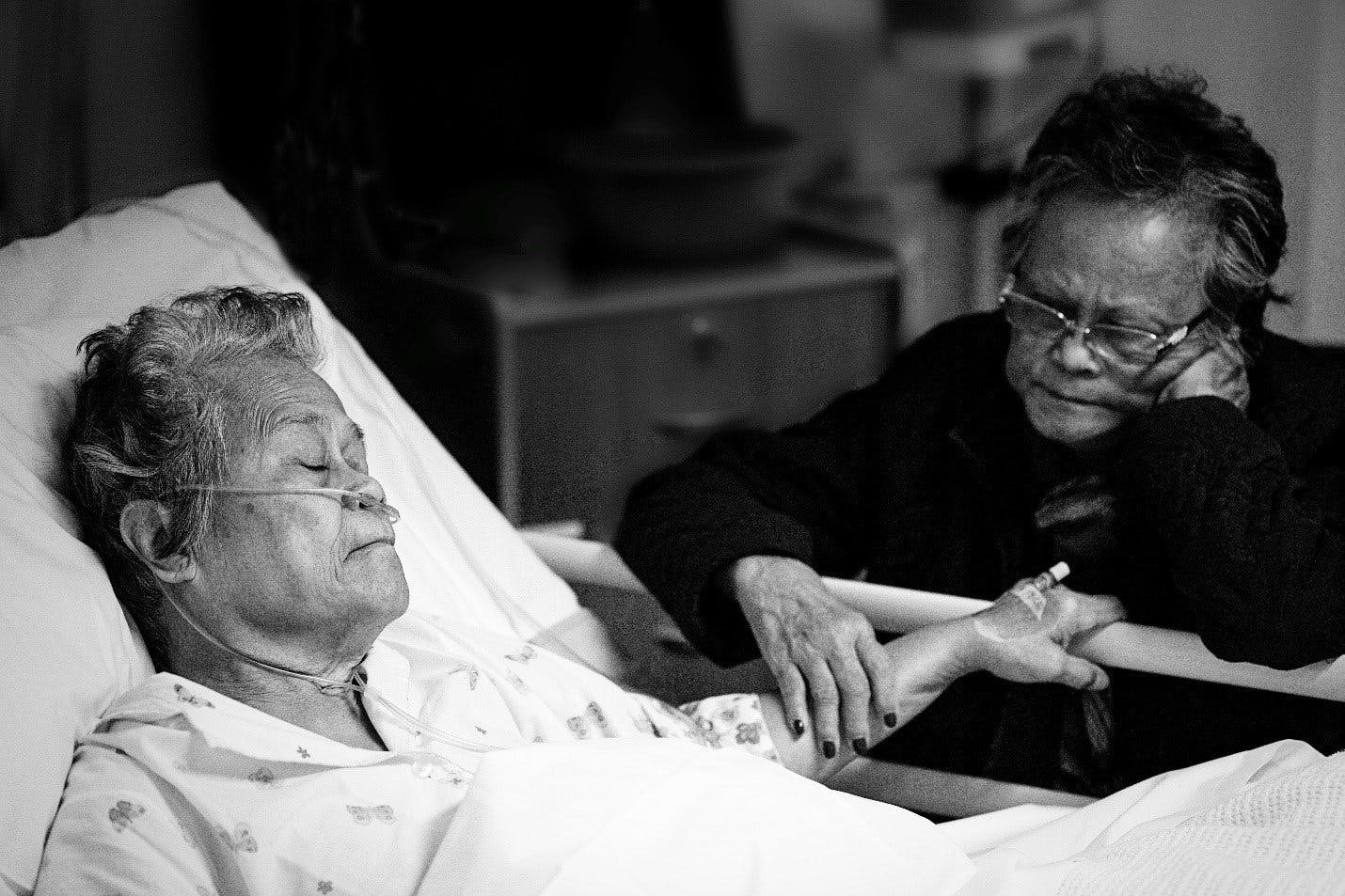 elderly-person-in-hospital-bed-with-guest