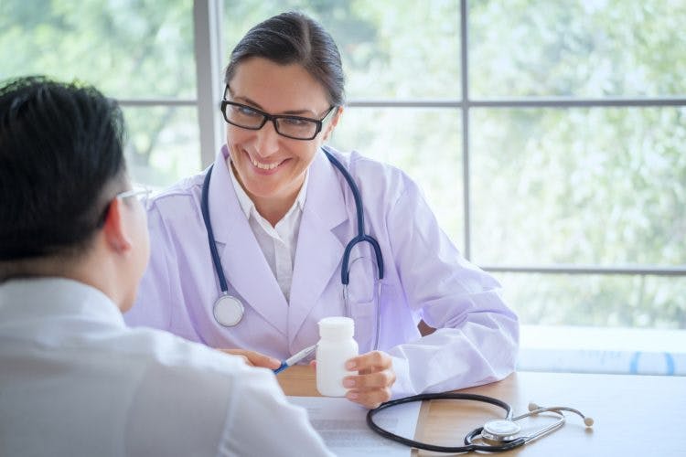 Senior Female doctor consults young Patient sitting at doctor of