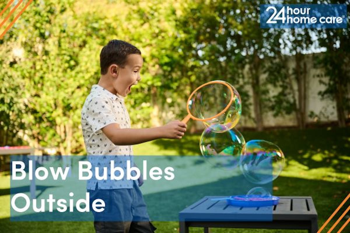 A child blows bubbles outside.