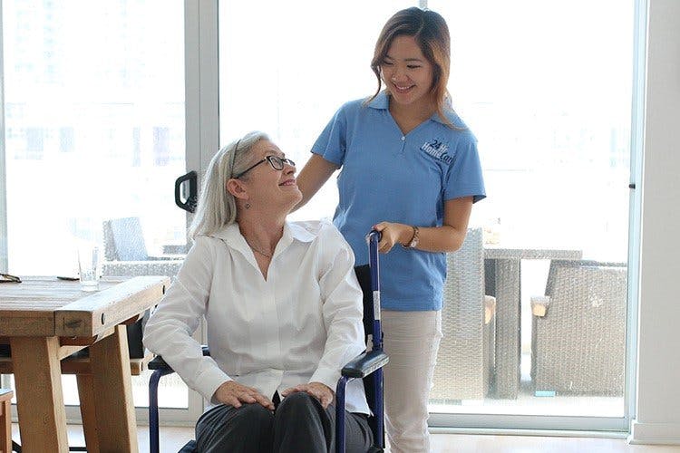caregiver-exchanging-smiles-with-woman-in-wheelchair