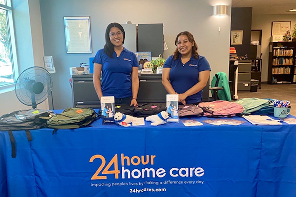 24 Hour Home Care employees pose with informational materials about the company.
