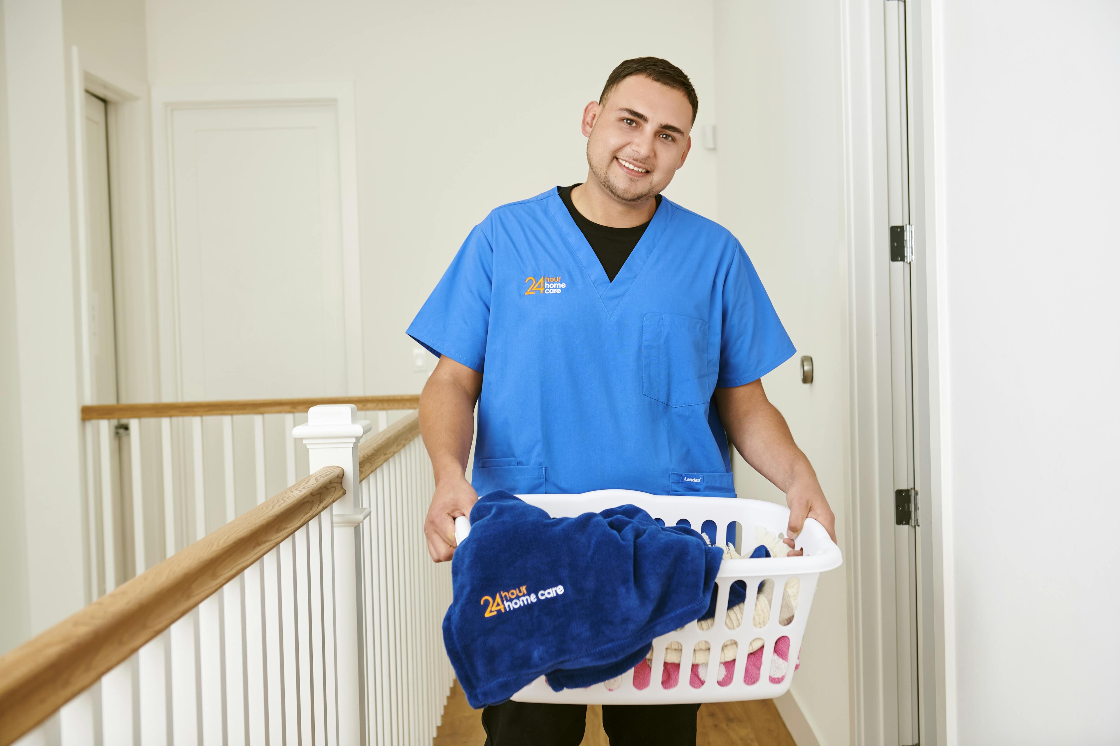 A 24 hour home care giver holding a laundry basket