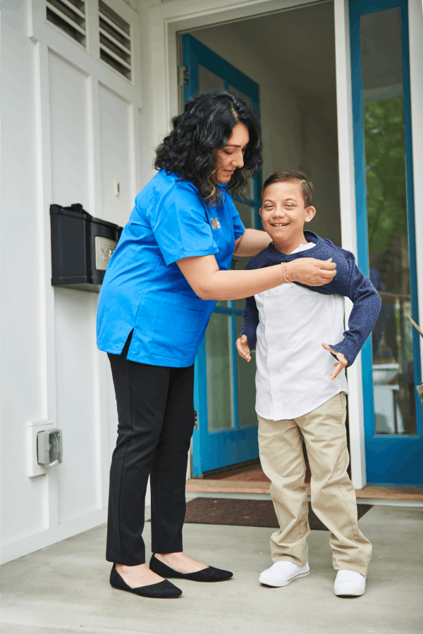 A caretaker helping a child get dressed