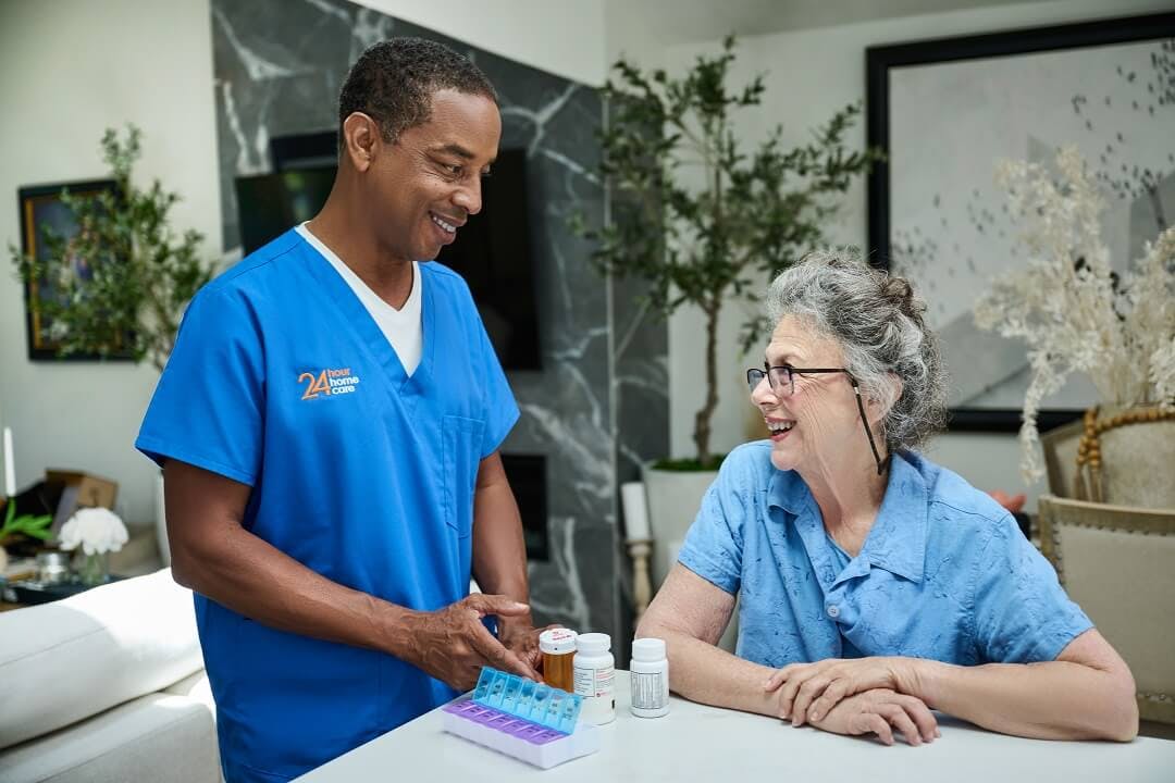 An adult caregiver helps his senior client with daily medication reminders.