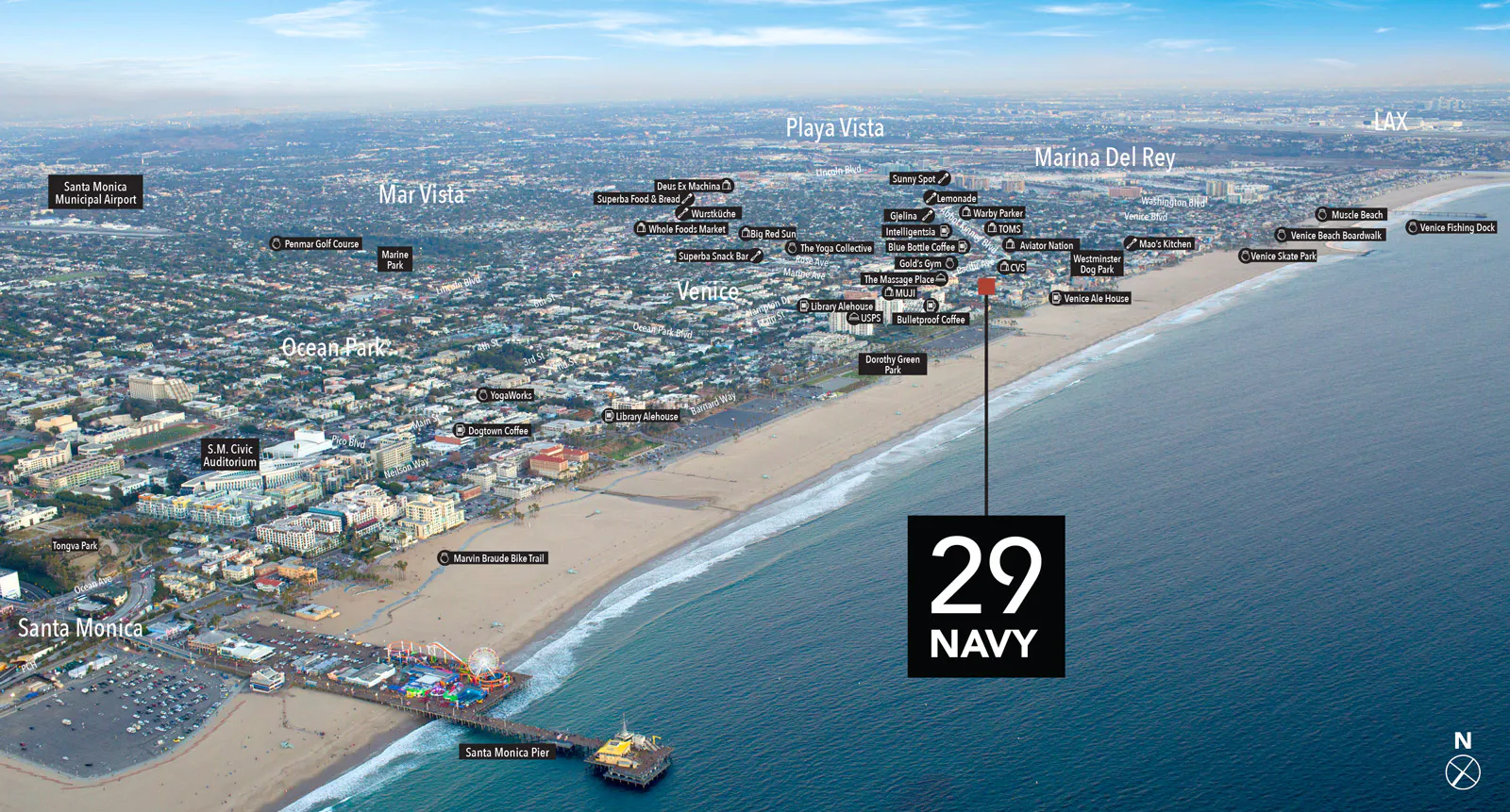 Aerial photograph looking down on the 29 Navy building and the surrounding Santa Monica blocks, with the beach and the Pacific beyond.