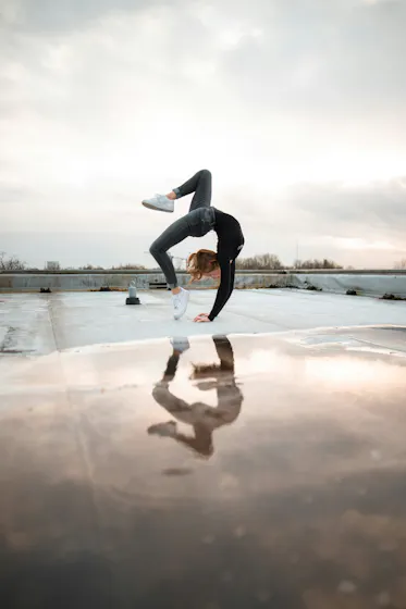 Woman doing backward flip representing dynamic learning and development and skills.