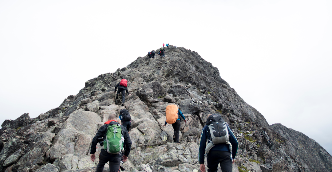 Team climbing a mountain representing effective leadership 