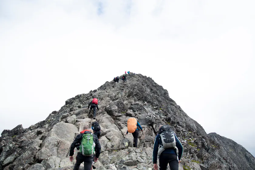 Team climbing a mountain representing effective leadership