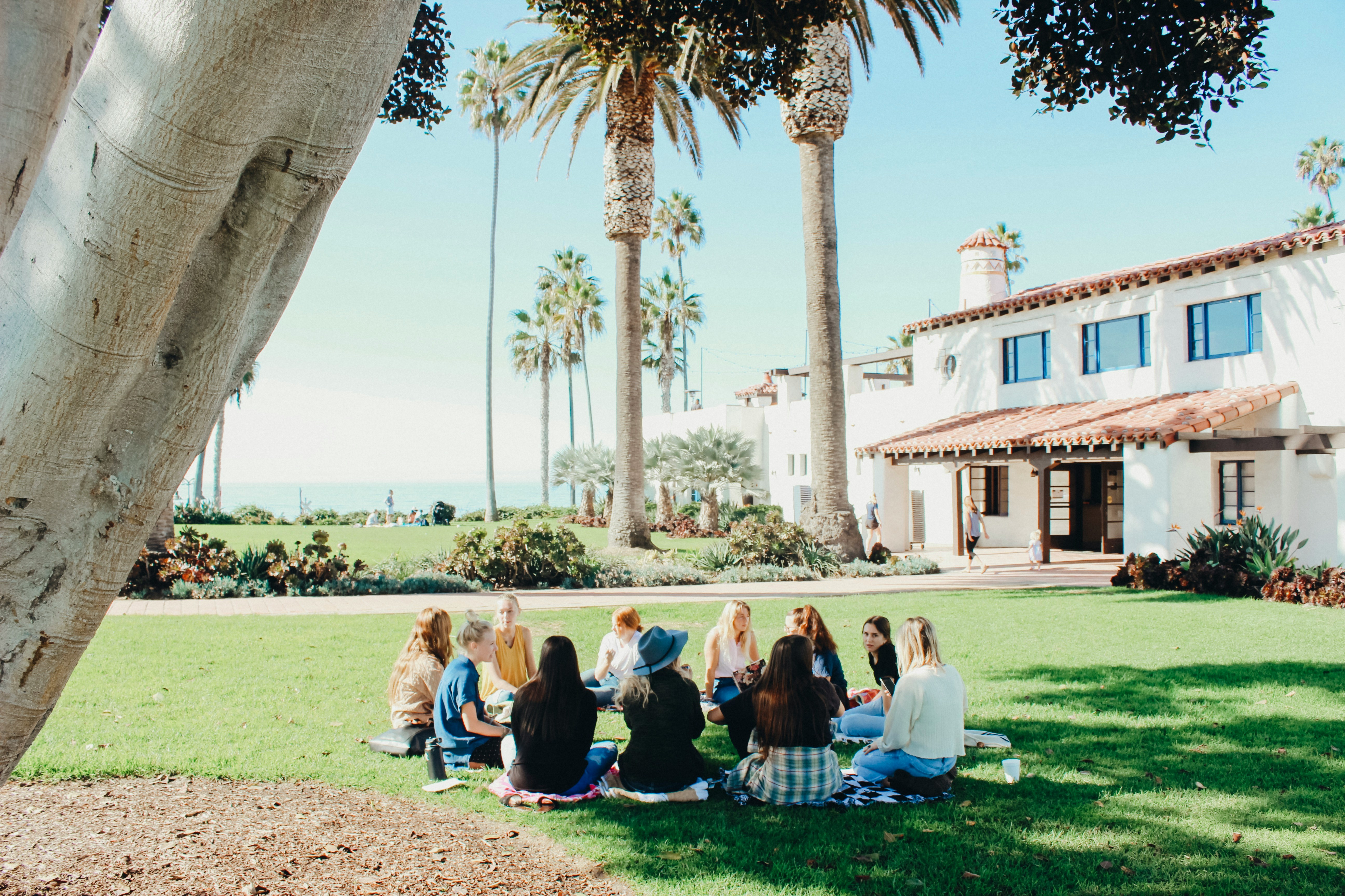 Women sitting in a circle on the lawn representing socialized learning communities