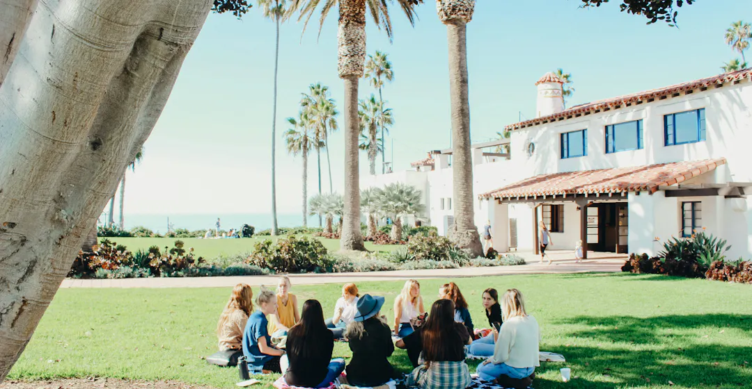 Women sitting in a circle on the lawn representing socialized learning communities