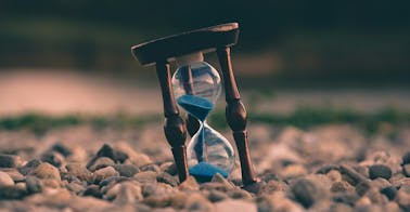 A running hourglass representing reframing organizational learning from time to value.