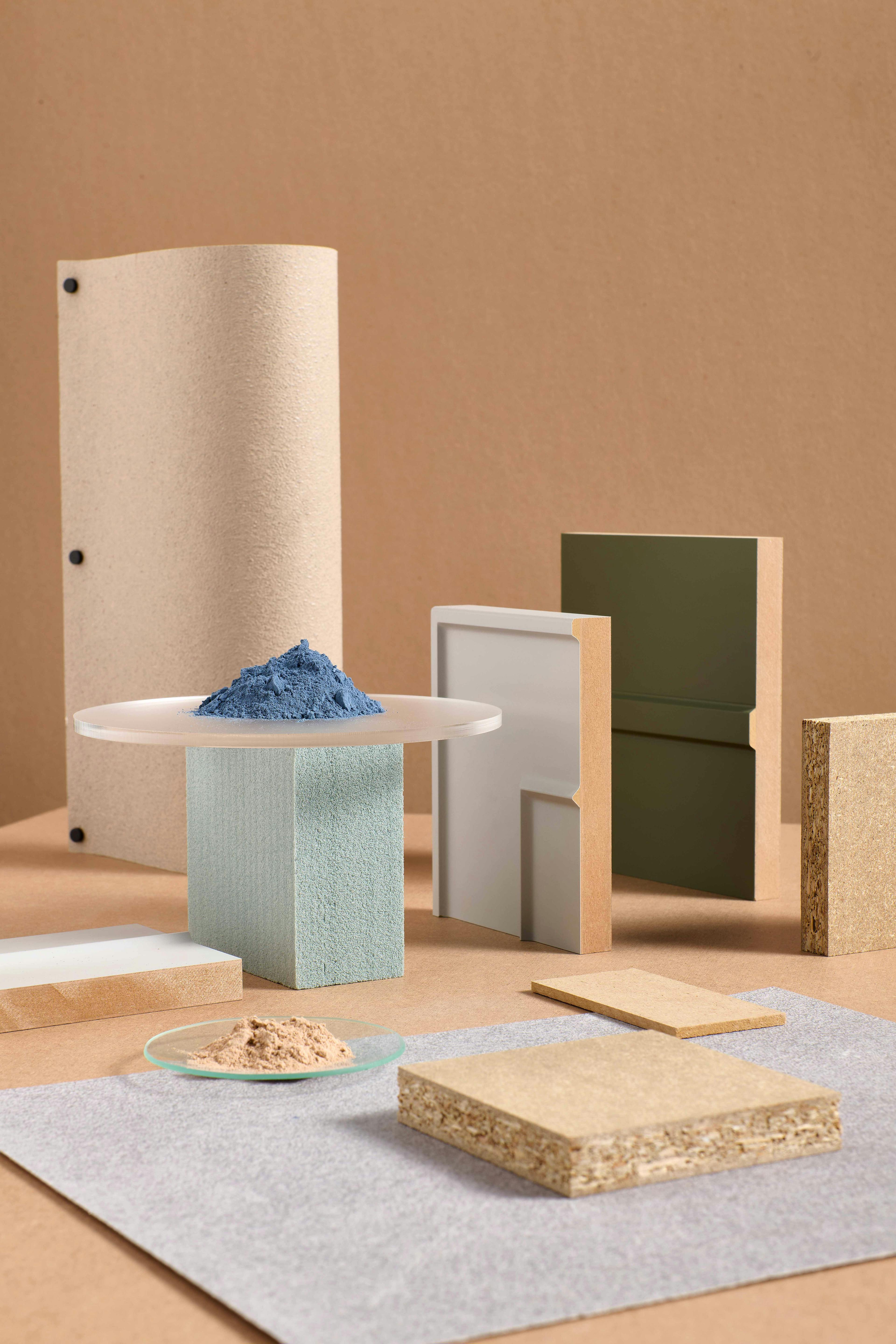 Geometric arrangement of panels and blocks of wood and similar materials in various shapes and sizes. The objects are placed on a beige surface, creating a minimalist atmosphere.