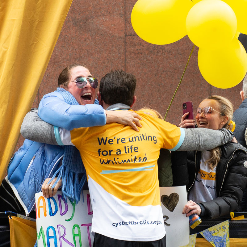 Runner in Cystic Fibrosis top hugging supporters