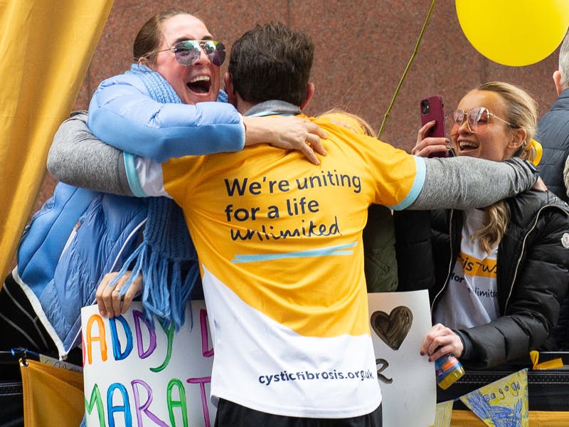 Runner in Cystic Fibrosis top hugging supporters
