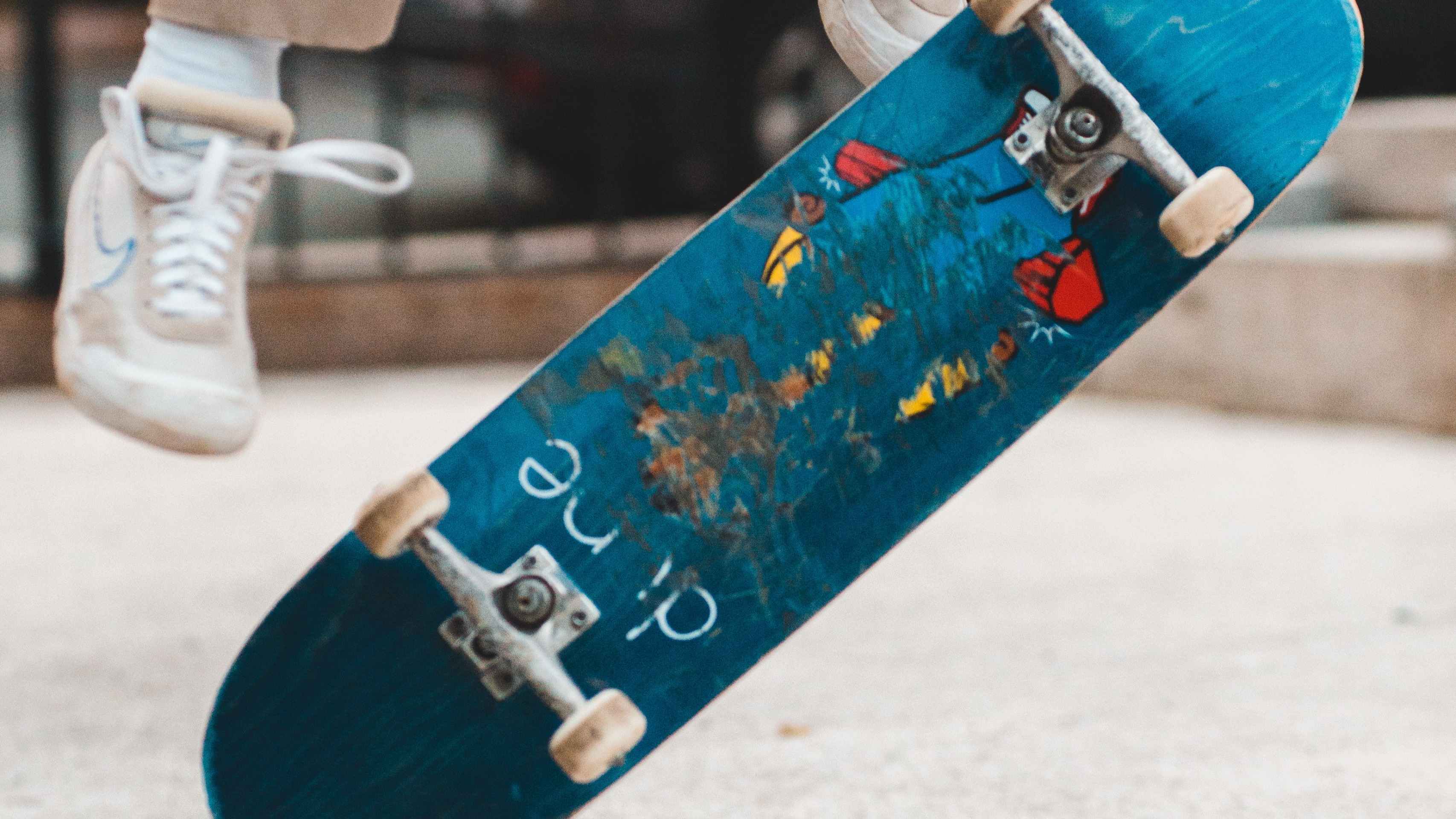 Skateboard flipping onto its side with feet in the air