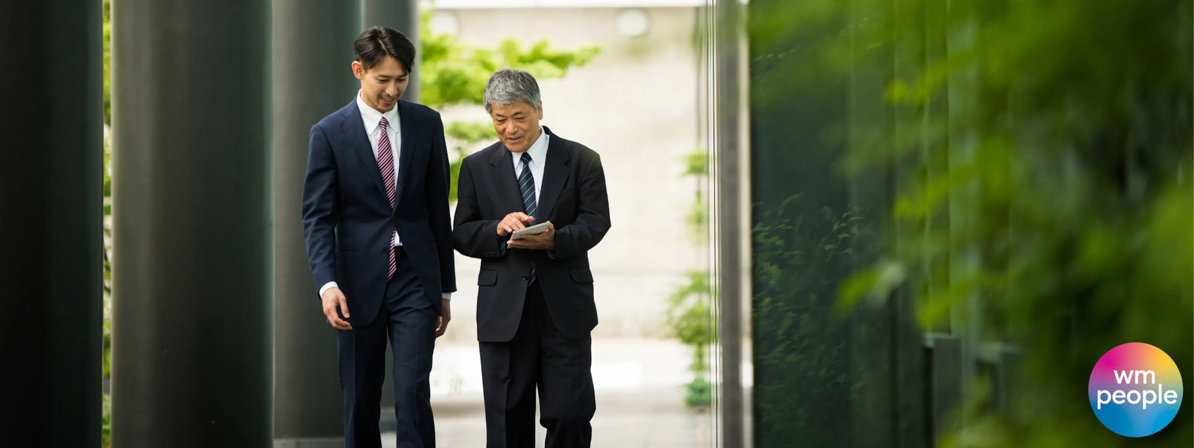 two men in suits walking and talking