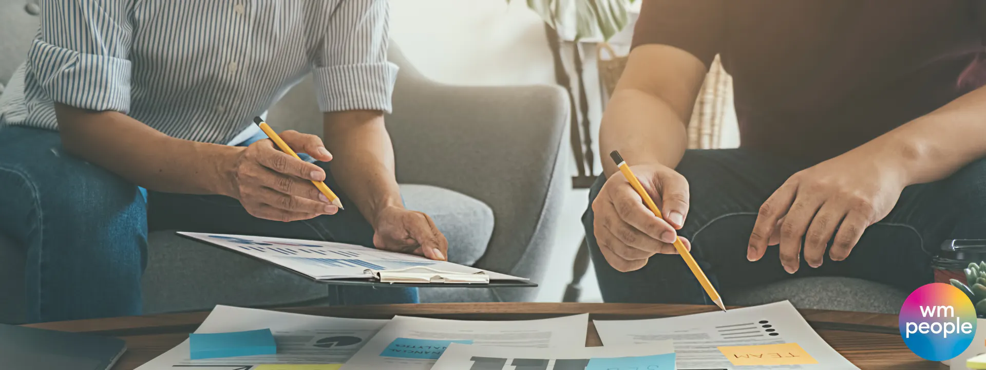 two people sitting discussing plans with paperwork
