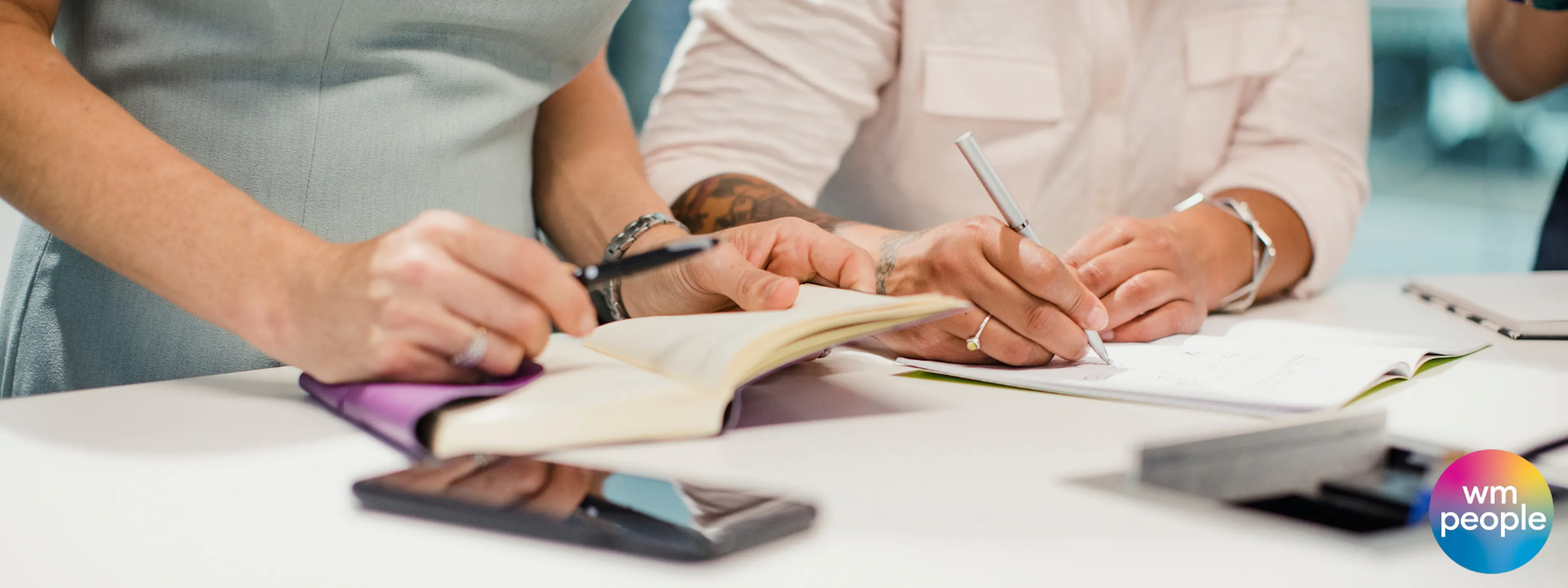 focus on two sets of  female hands at a desk