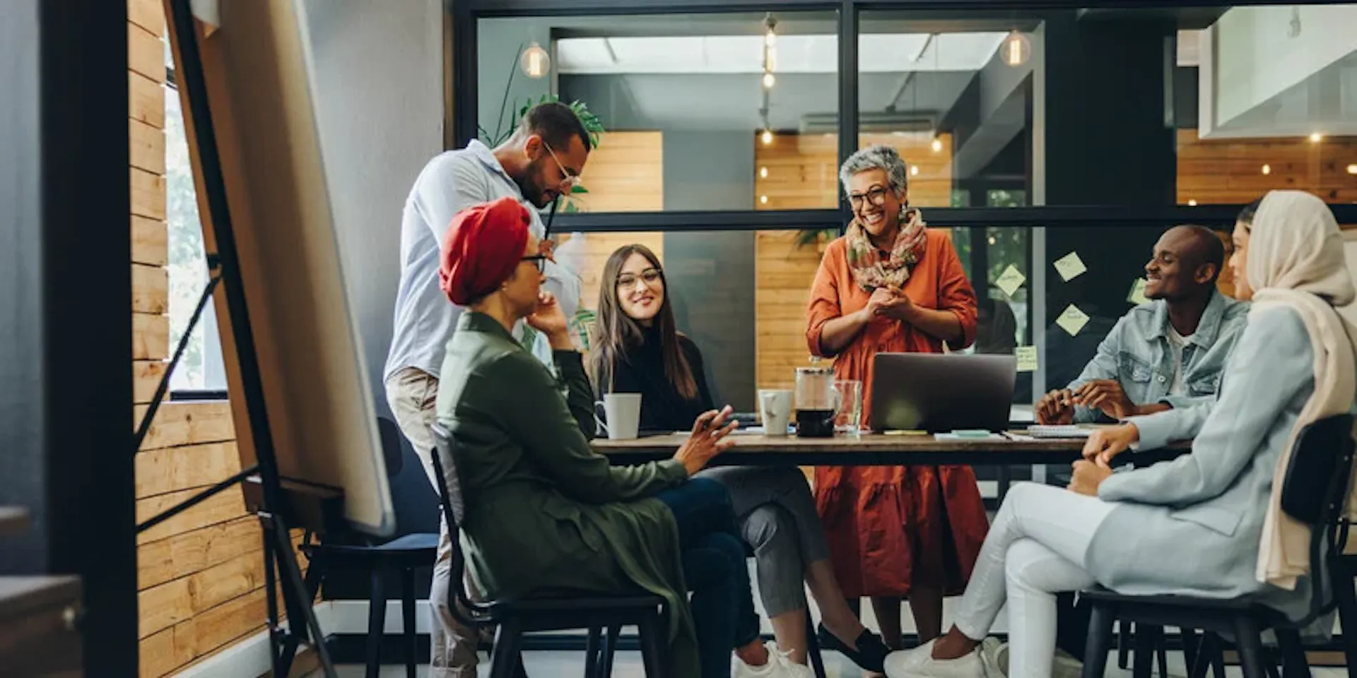 Colleagues of different ages talking around a table in an office meeting