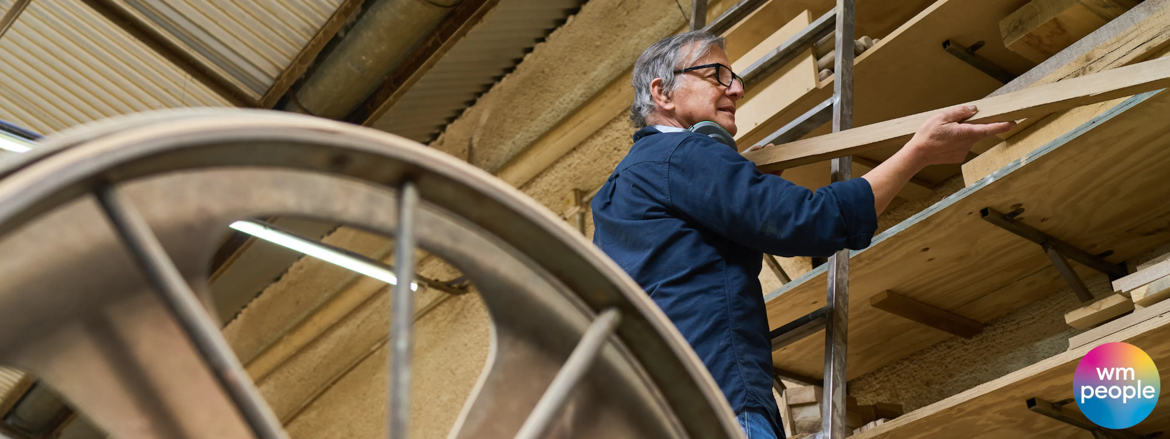 Older skilled craftsperson selecting a length of wood