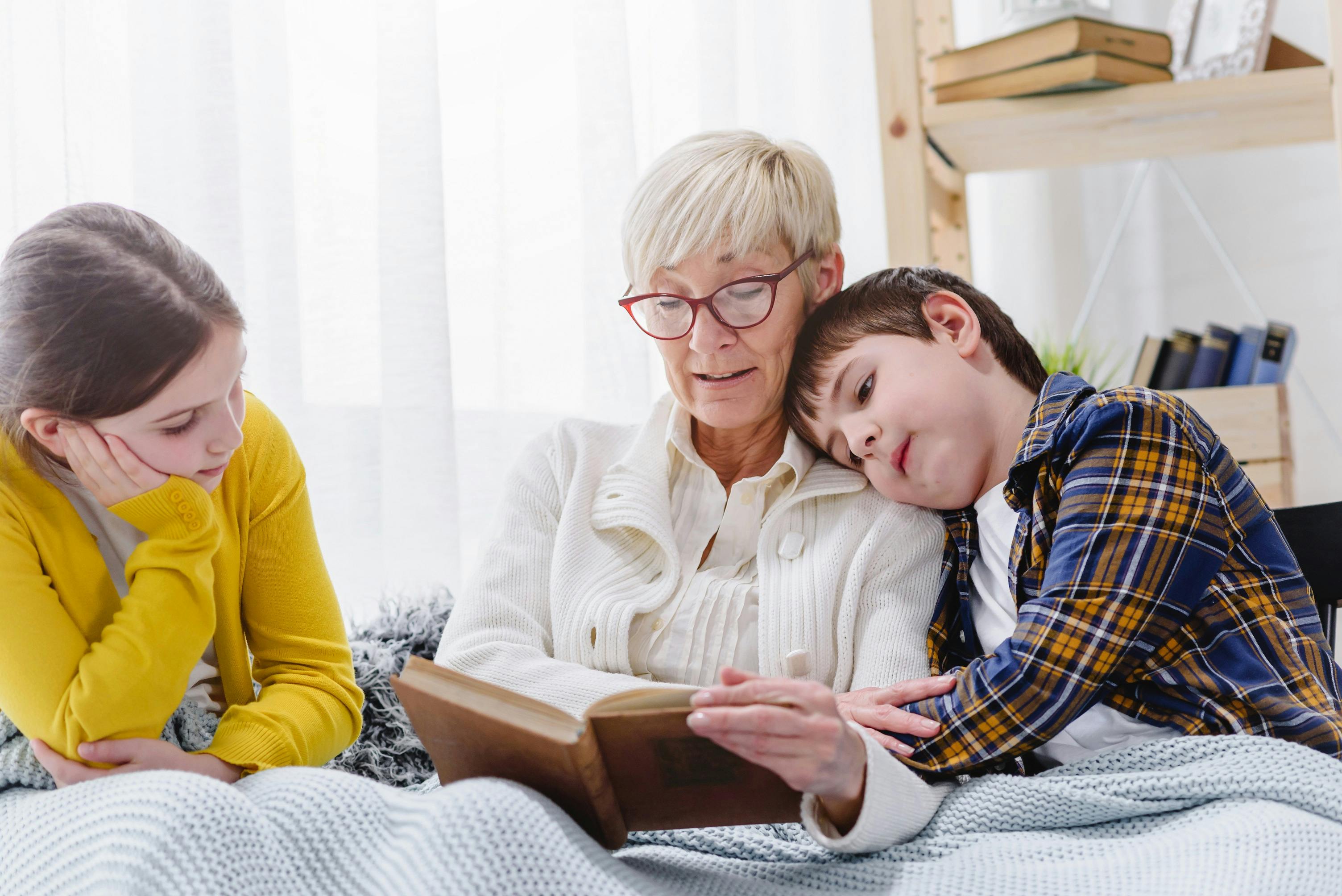 grandmother reading bedtime story to grandchildren