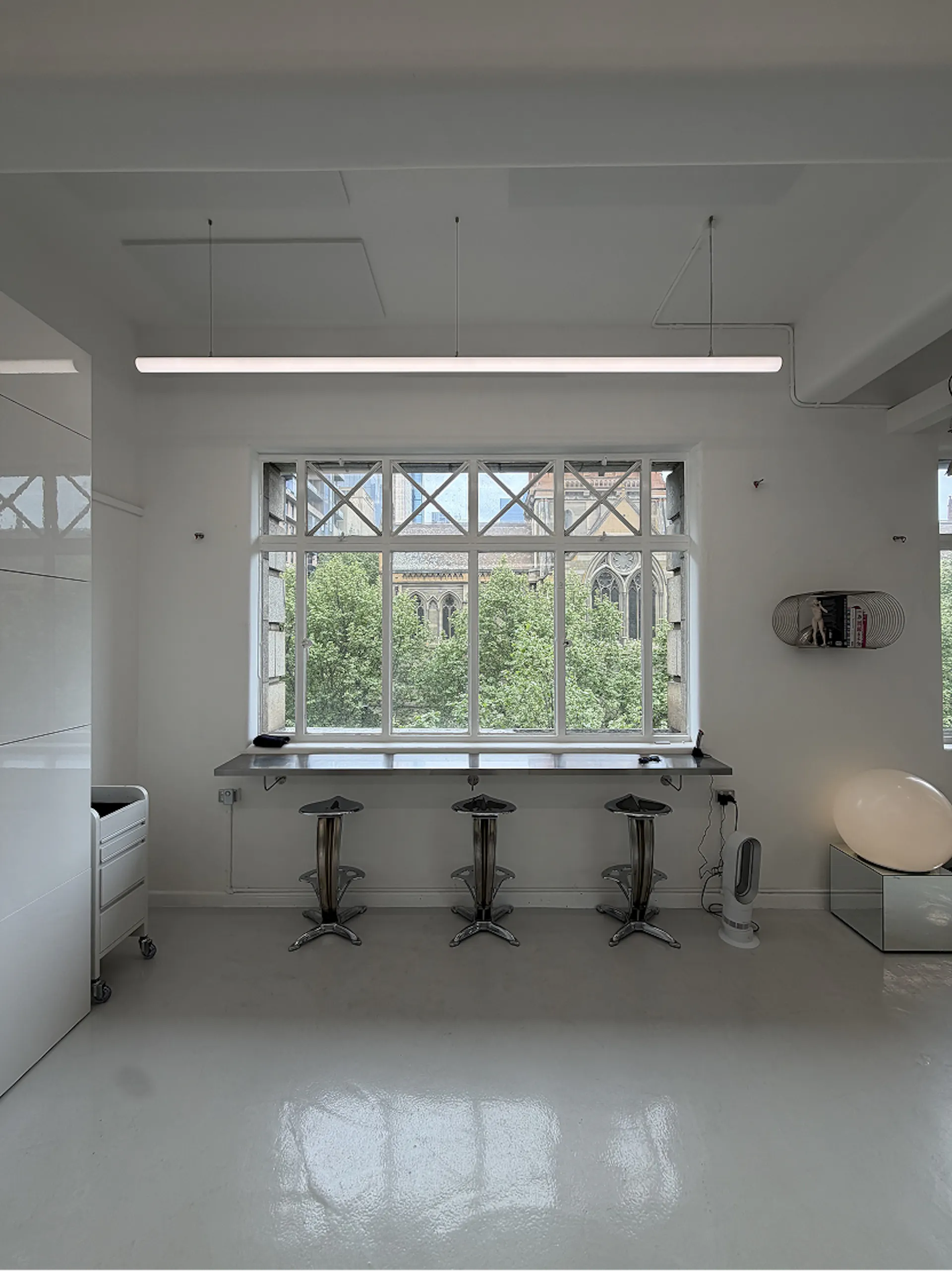 Window bench with three chrome stools overlooking the city