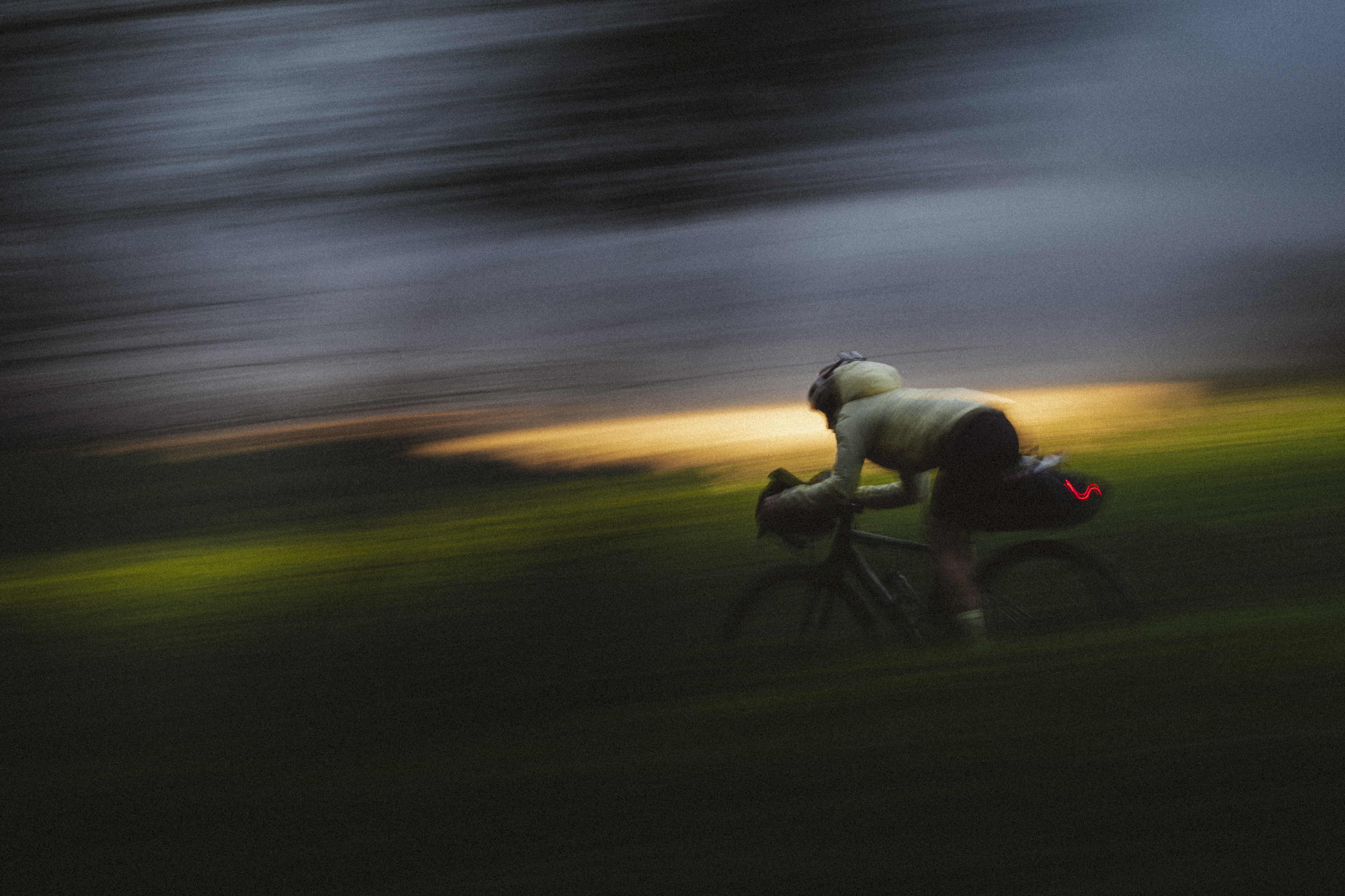Rider crossing a hilltop field in the last of the evening light