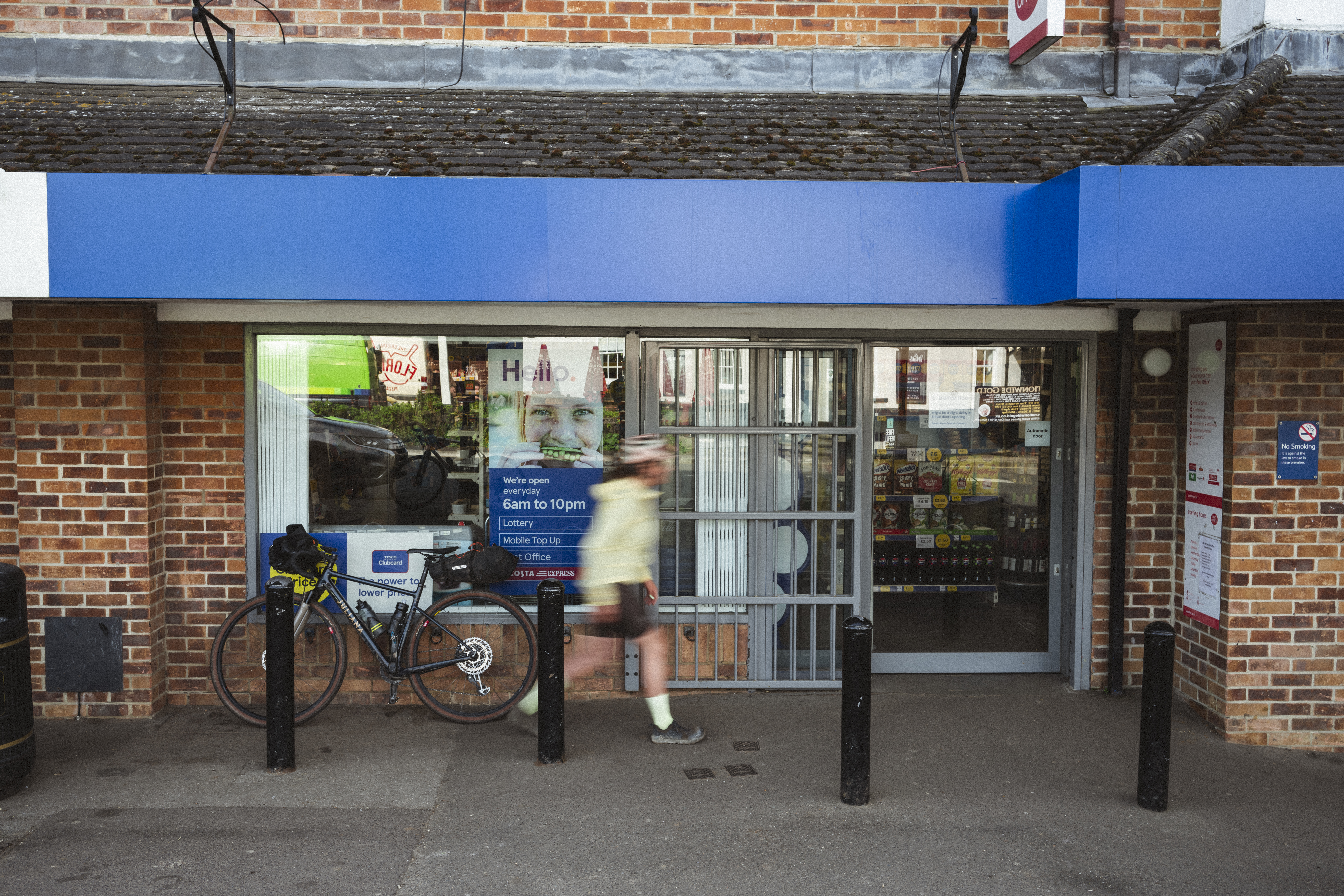 Loaded gravel bike leaning outside a village convenience store at dusk