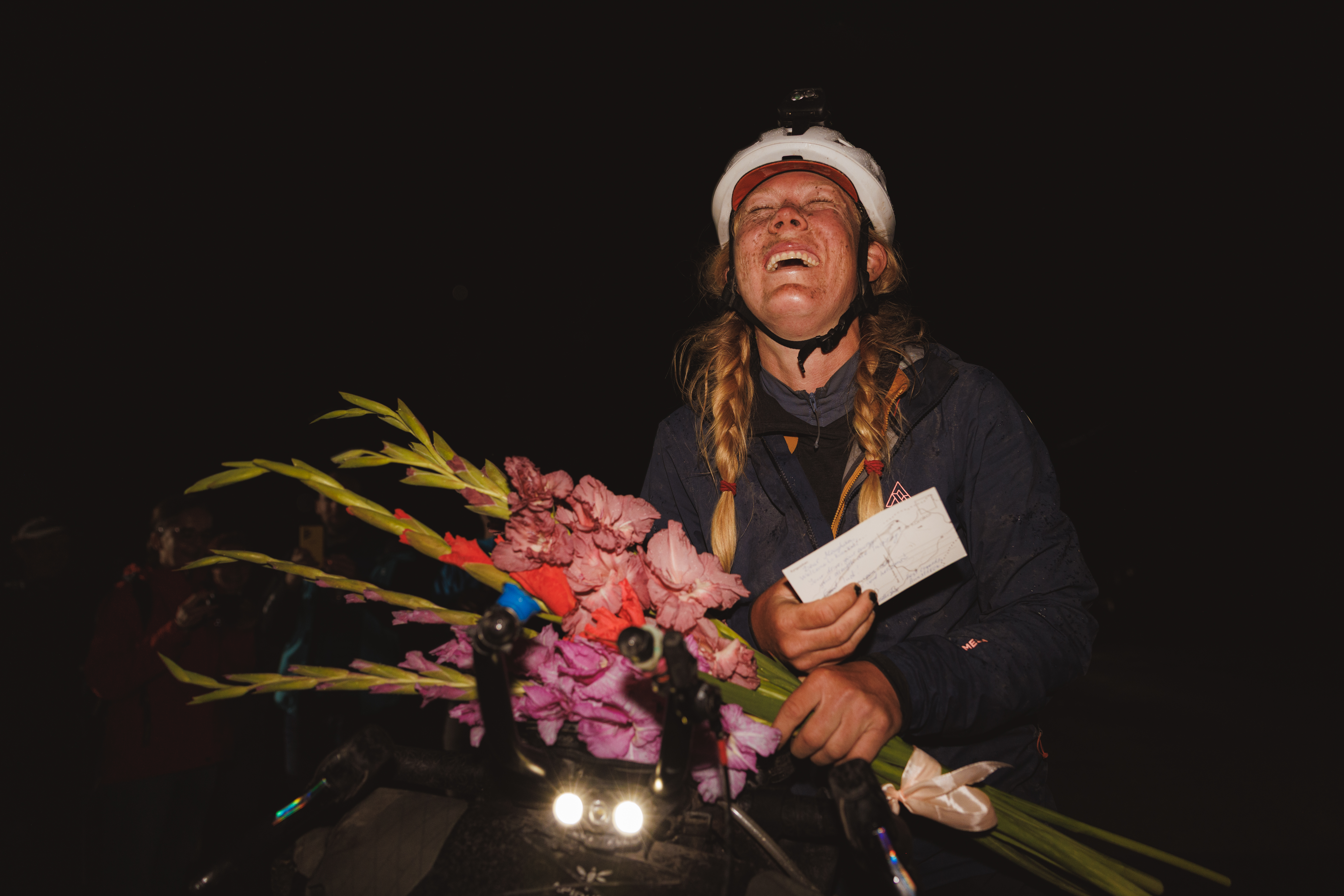 Rider at night holding a bouquet of flowers and an envelope, eyes closed
