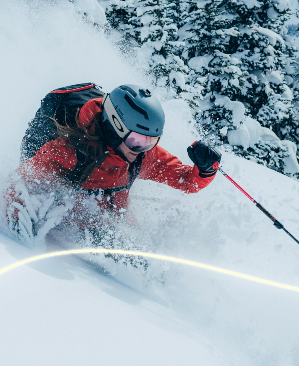 Skiier in powder wearing red jacket