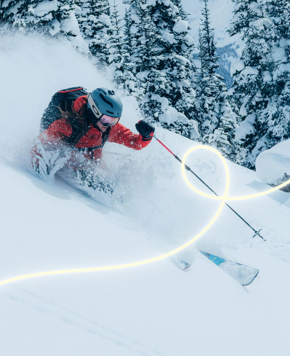 Skiing in deep powder wearing a red jacket with a holiday string of lights overlayed on the image