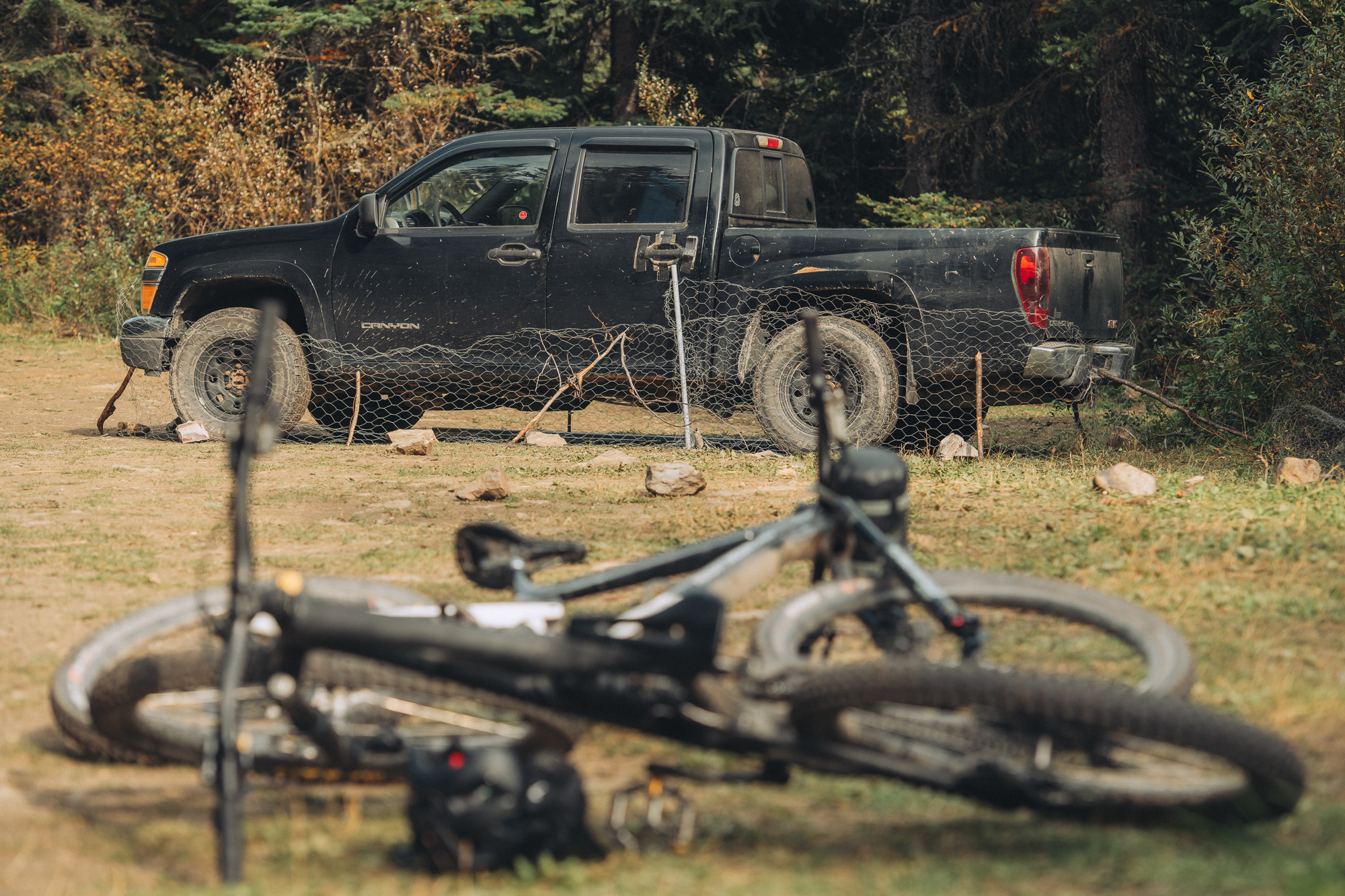 Loaded bike lying in the grass in front of a parked pickup truck