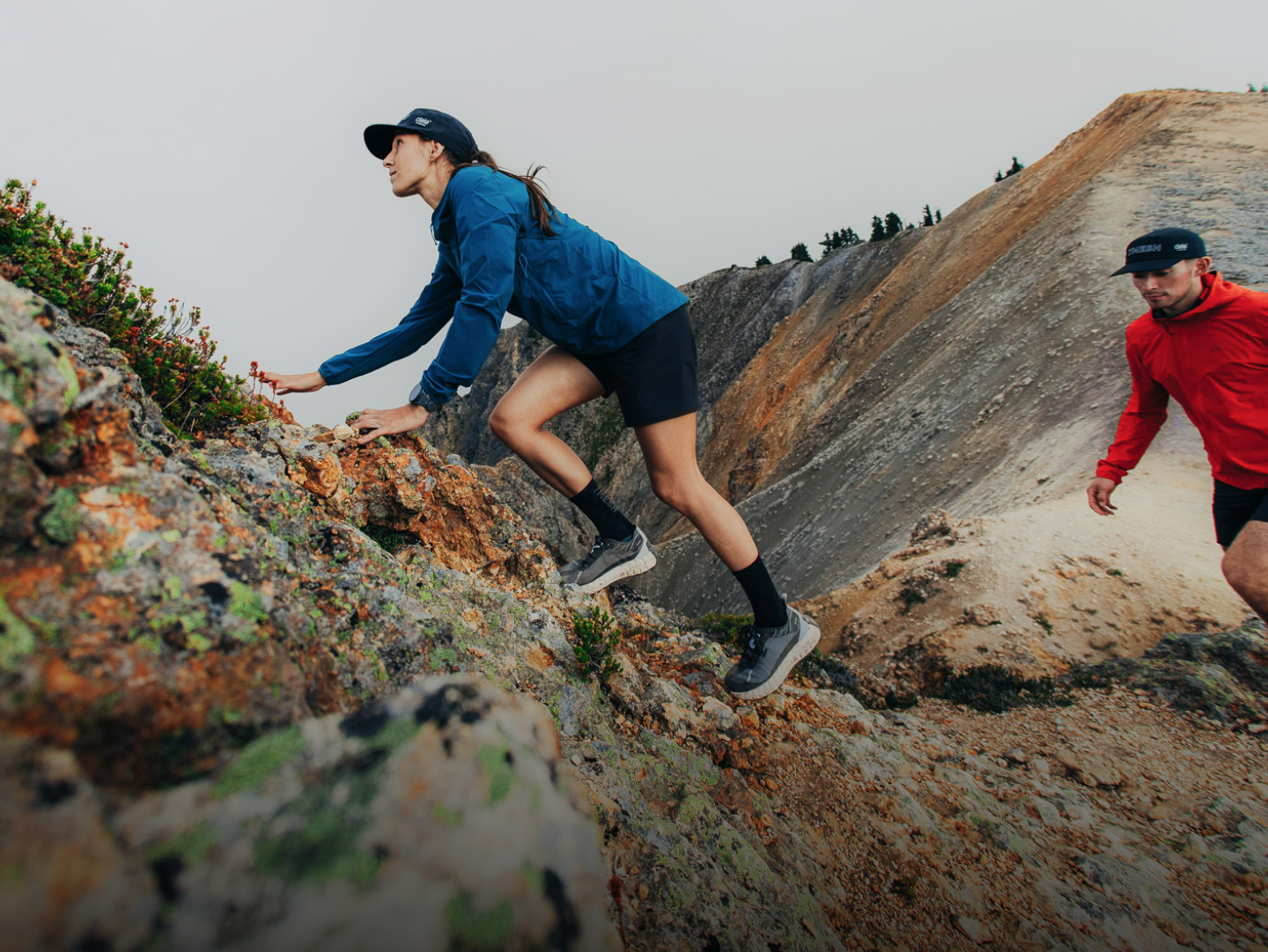 Women in blue jacket climbing a mountain wearing 7mesh shorts